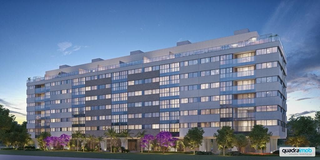 Fachada noturna do edifício residencial com varandas e iluminação.