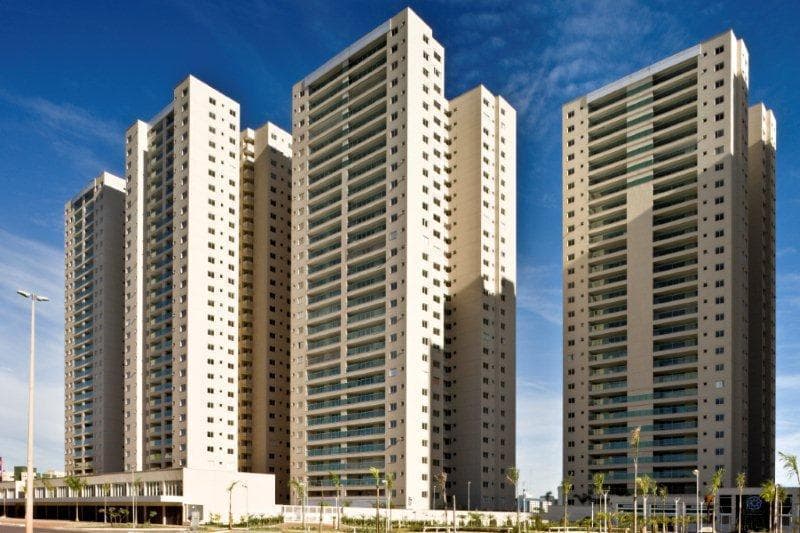 Fachada externa dos prédios do condomínio com torres residenciais e céu azul