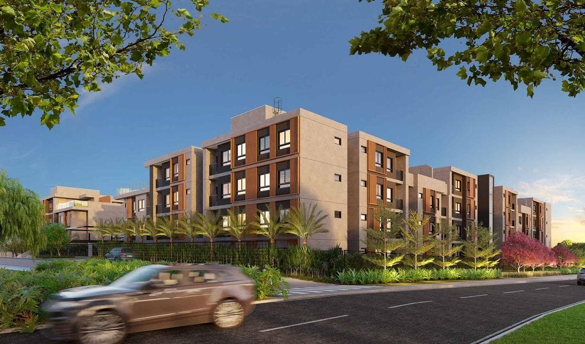 Fachada do edifício residencial com varandas e vegetação na calçada.