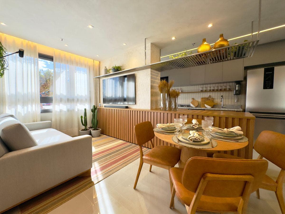 Sala de estar integrada com jantar, com sofá, TV na parede, painel ripado e mesa redonda
