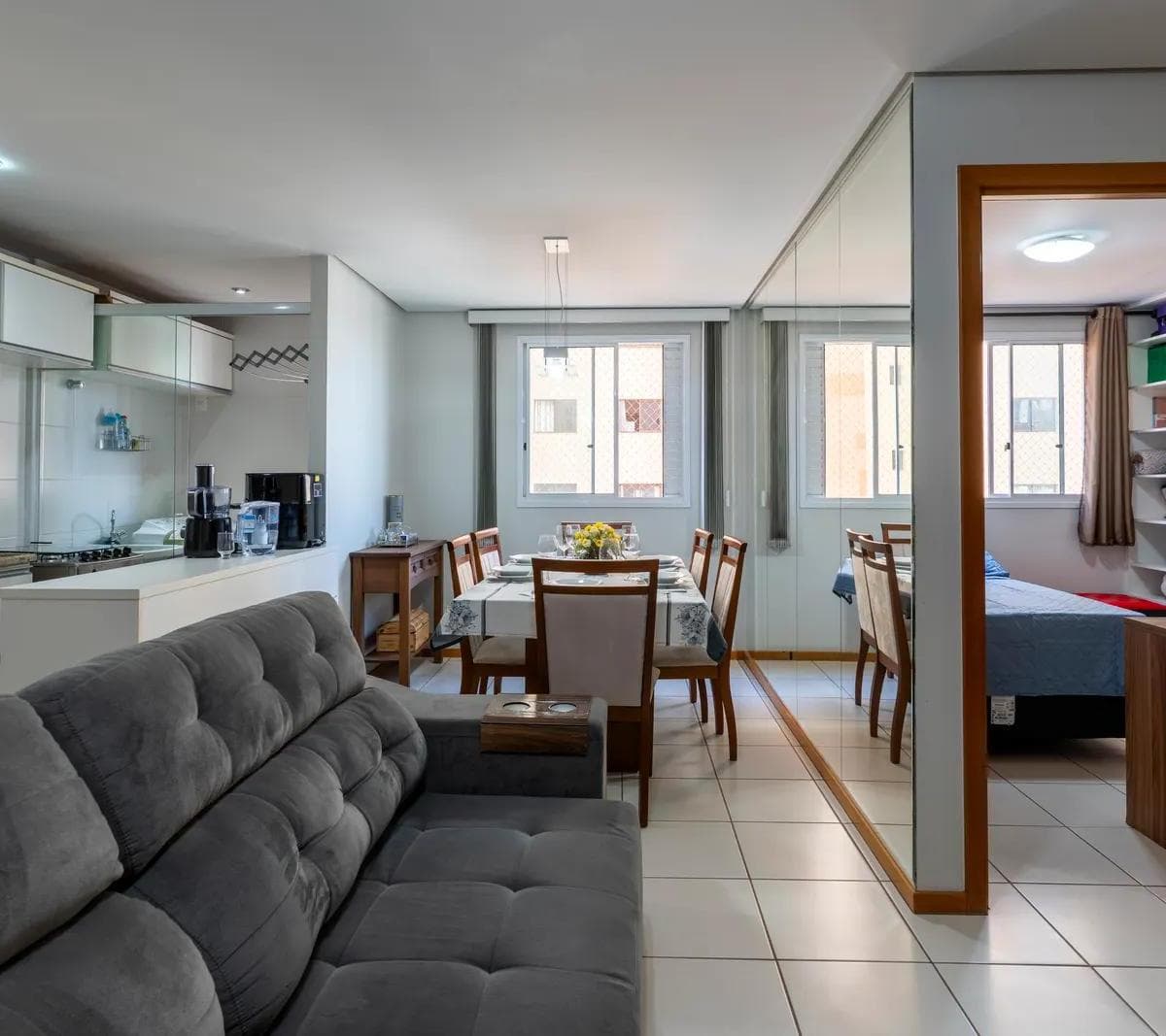 Sala de estar com sofa cinza, integracao com jantar e cozinha