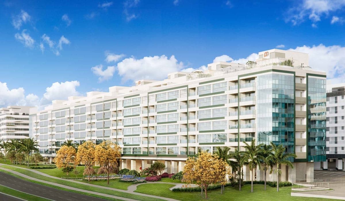Fachada frontal do edifício residencial com paisagismo e árvores