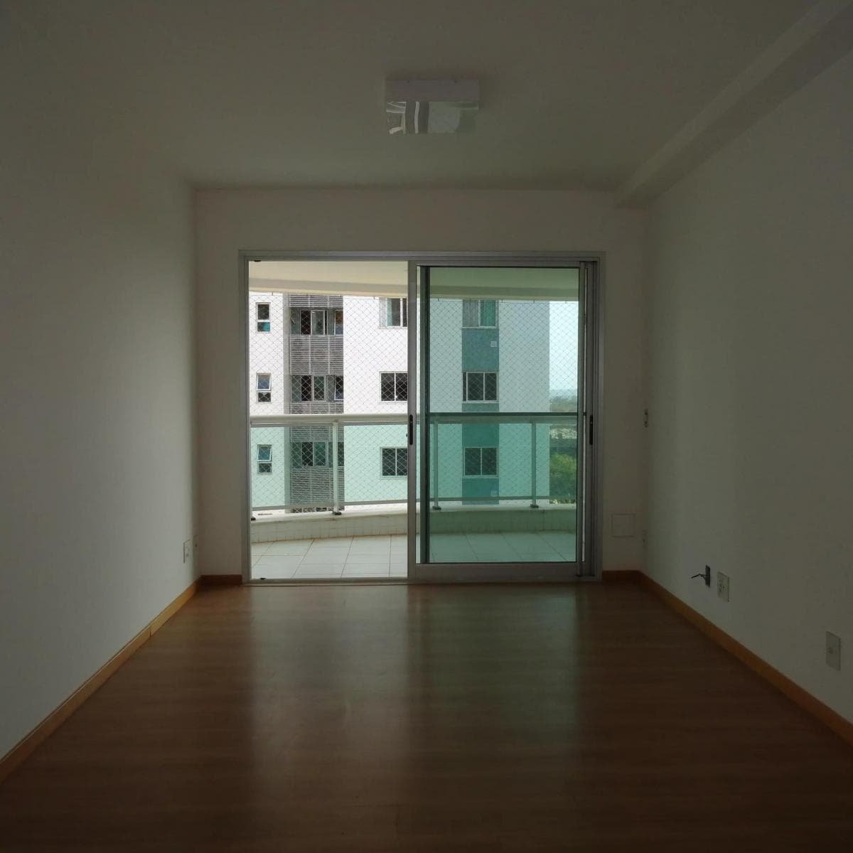 Vista interna da sala em direcao a porta de vidro da varanda.