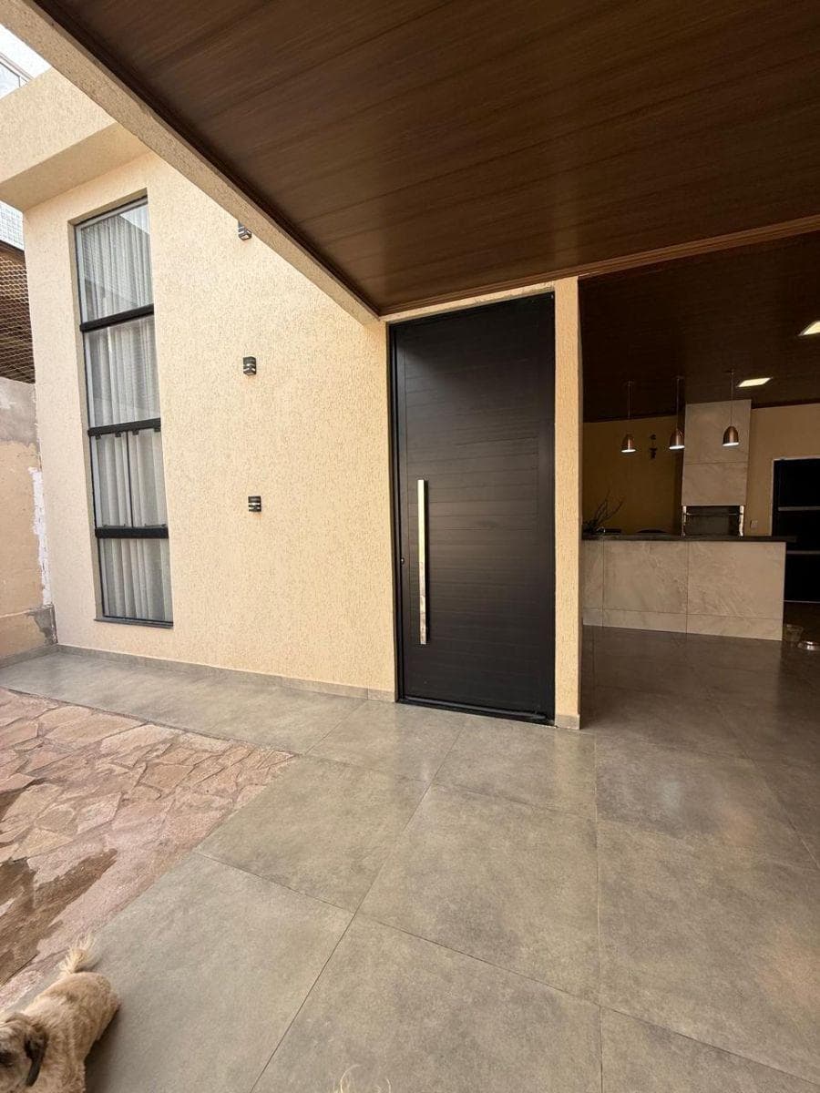 Fachada moderna com porta de entrada escura e teto revestido em tom amadeirado