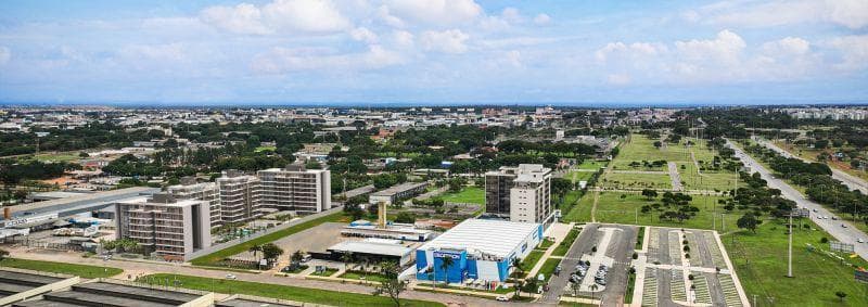 Vista panorâmica da região a partir do andar alto com área verde e construções.