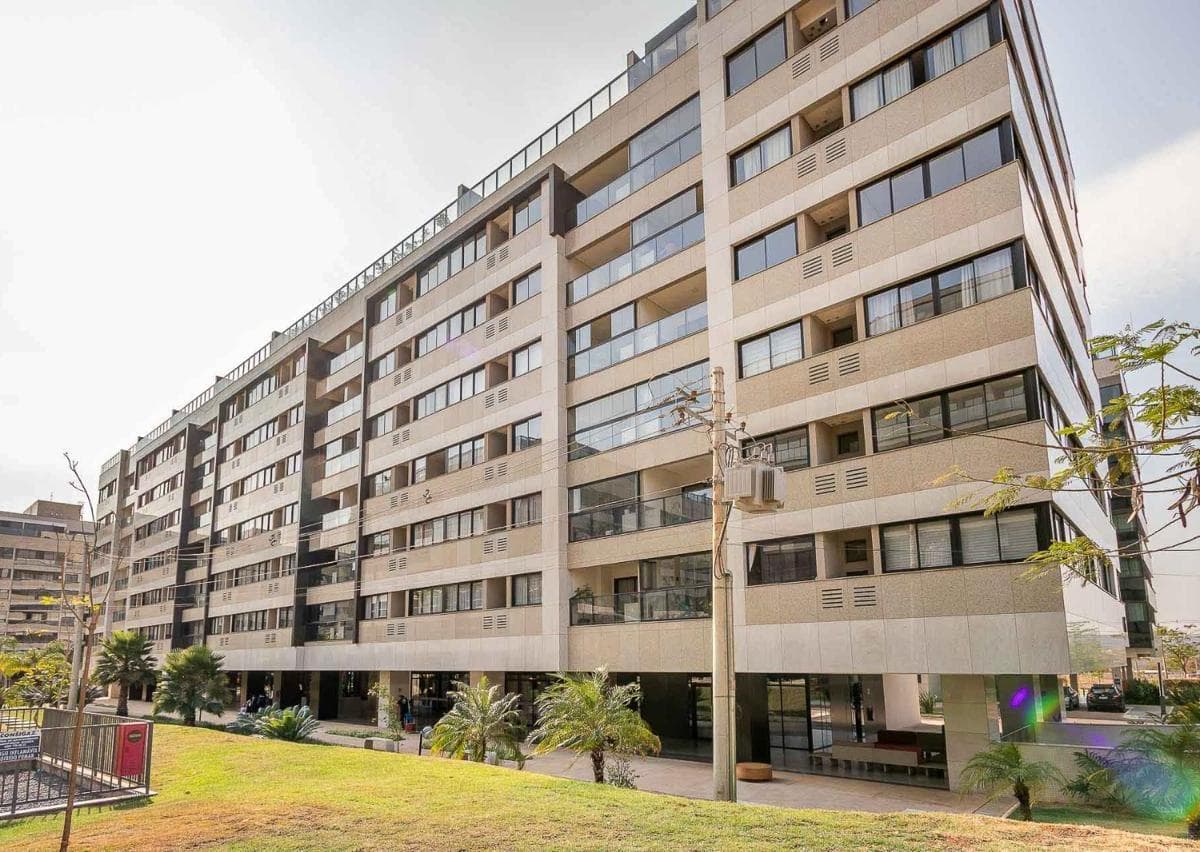Fachada do edifício residencial com revestimento em tom claro e varandas.