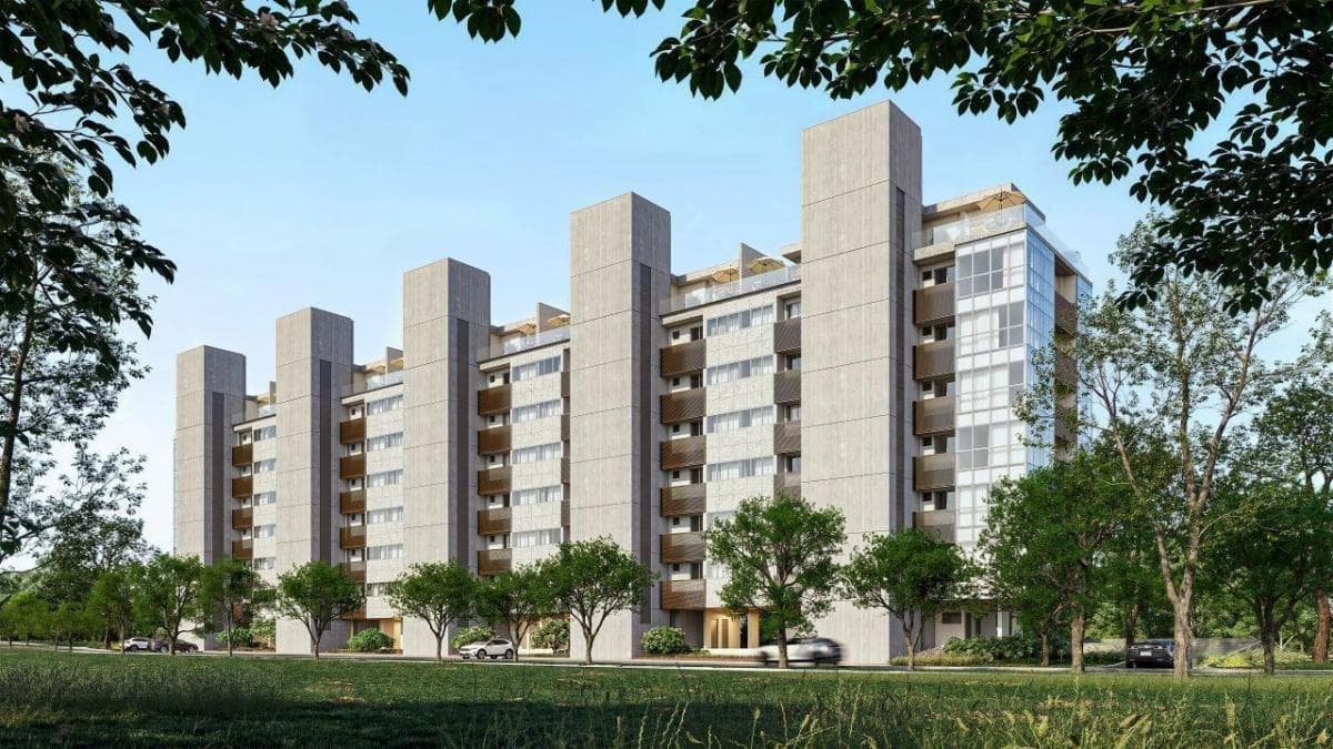Fachada do edificio com estrutura em concreto aparente, varandas e arborizacao frontal.